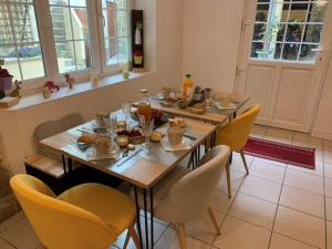 een eettafel met stoelen en eten erop bij Chambre d'hôtes Logis de Saint Jean in Bayeux