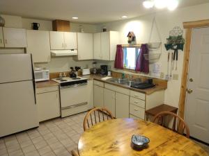 een keuken met witte apparatuur en een houten tafel bij Hall Creek Cabin in Packwood