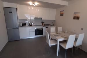 a kitchen with a table and chairs and a kitchen with white cabinets at New Appartement, fully air conditioned, South Tenerife! in La Tejita