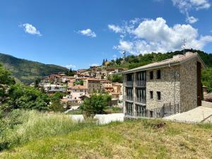 a small stone building in front of a village at Apartaments Turístics Cal Patoi in Martinet