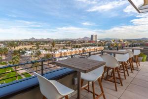 a balcony with tables and chairs and a view of the city at Cambria Hotel Downtown Phoenix in Phoenix