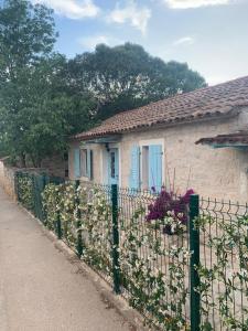 una recinzione di fronte a una casa con una finestra blu di Vila Majda a Vabriga