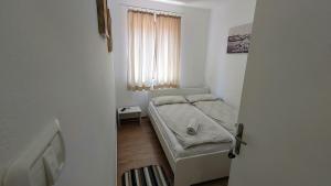 a small room with a bed and a window at B&B Vongola Izola in Izola