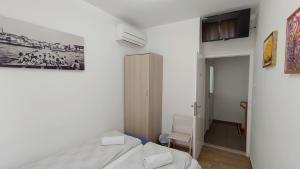 a bedroom with a bed and a tv on the wall at B&B Vongola Izola in Izola