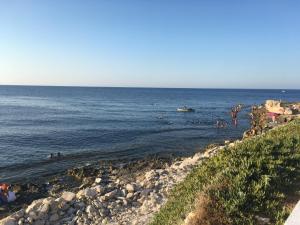 a group of people in the water at a beach at El Hamra Maison Traditionnelle in Mahdia