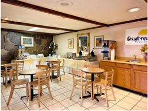 a restaurant with tables and chairs and a counter at Ramadaby Wyndham Pittsburgh-New Stanton in New Stanton
