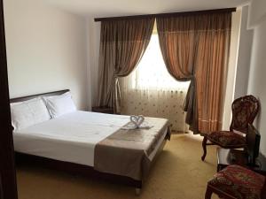 a bedroom with a bed and a chair and a window at Orient Mamaia Nord in Mamaia Sat/Năvodari +38 photos