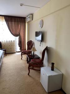 a living room with two chairs and a couch and a window at Orient Mamaia Nord in Mamaia Sat/Năvodari