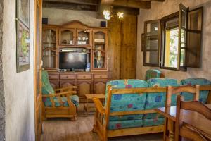 a living room with chairs and a television in a house at casa el susurro in Ponferrada