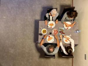 un grupo de personas sentadas en una mesa comiendo comida en Apartaments Turístics Cal Patoi, en Martinet