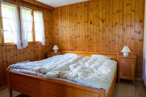 una camera da letto con un grande letto e pareti in legno di Chalet Orion a Bellwald