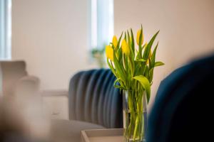 a vase filled with yellow flowers sitting on a table at Charles Alexander Short Stay - Windmill House Apartments in Lytham St Annes