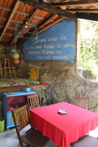 czerwony stół z krzesłami i znak na ścianie w obiekcie 5ª d'azenha - River and Nature w mieście Amarante