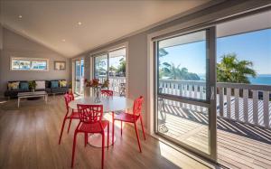 a dining room with a table and chairs on a balcony at THE WAIHEKE PAD - in the heart of Oneroa! in Oneroa