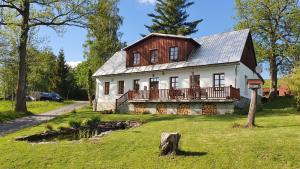 una gran casa blanca con techo de gambrel en Kněžice 25, chalupa v Krkonoších en Vrchlabí