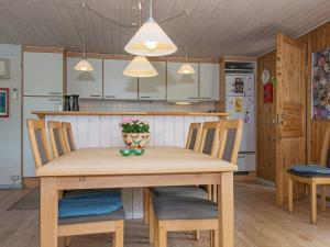 6 person holiday home in Glesborg في Bønnerup: مطبخ وغرفة طعام مع طاولة وكراسي خشبية