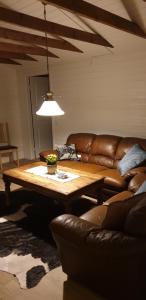 uma sala de estar com uma mesa e um sofá de couro em Camp Wild West em Höör