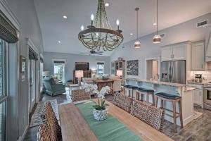 a kitchen and living room with a table and chairs at Quiet Fishermans House with Hot Tub and Tropical Bar! in Dauphin Island