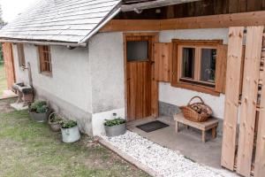 een klein huis met een houten deur en een bank bij Holiday House Franc in Srednja Vas v Bohinju