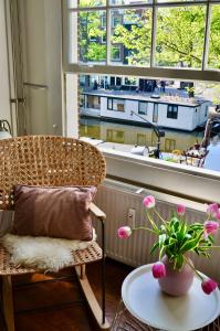 a wicker chair and a table in front of a window at Homeawayhome C&R 1 in Amsterdam