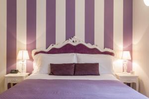 a bedroom with a bed with purple and white stripes at Giardino Giusti House & Court in Verona