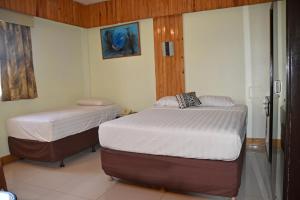 A bed or beds in a room at Grand Melanesian Hotel