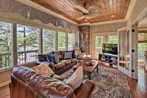 a living room with a leather couch and a tv at Luxury Hot Springs Oasis on Lake with Private Dock! in Hot Springs