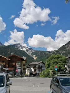 a parking lot with cars parked in front of a mountain at Courma House in Courmayeur