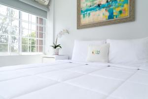 a white bedroom with a white bed and a painting at Choose To Be Happy at Seymour # 9 and #16 - Studio Apartments in Kingston