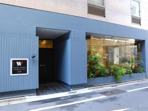 una puerta delantera de un edificio con un cartel en Hotel Wing International Ikebukuro, en Tokio