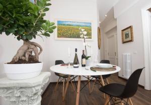 ein Esszimmer mit einem weißen Tisch und einer Topfpflanze in der Unterkunft SAN GIOVANNI APARTMENT 80 MQ in Rom