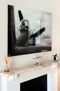 a picture of a plane hanging over a fireplace at ARCORE Premium Rental Grafton Way in London