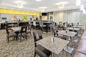 a restaurant with tables and chairs and a bar at La Quinta by Wyndham Elk City in Elk City