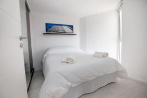 a bedroom with a white bed with a picture on the wall at Alma de Agua Resort in Federación