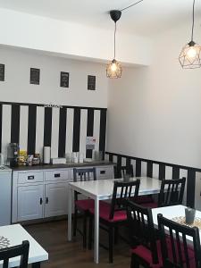 a kitchen with white tables and chairs and black and white stripes at House LA Neuschwanstein Blick in Füssen