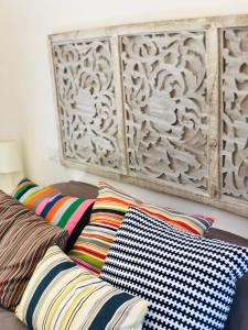 eine Couch mit bunten Kissen und einer Holzwand in der Unterkunft Suite Paraiso in Ostuni