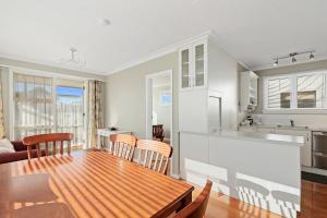 a kitchen and dining room with a table and chairs at Coastal City Retreat - New Brighton Accommodation in Christchurch