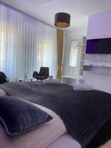 a bedroom with a large bed with a black blanket at Heidepension Bispingen in Bispingen