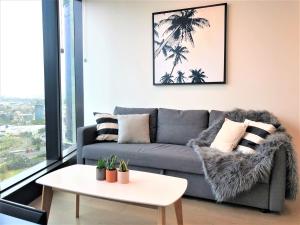 a living room with a couch and a table at ReadySet Apartments on Southbank Boulevard in Melbourne