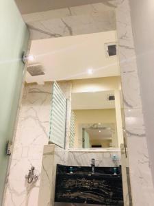 łazienka z umywalką i dużym lustrem w obiekcie أول سويت w Rijadzie