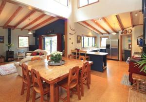 a kitchen and living room with a wooden table and chairs at Waiheke Escape in Palm Beach