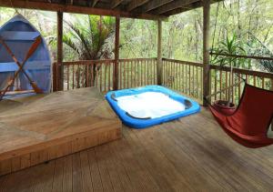 a hot tub and a hammock on a deck at Waiheke Escape in Palm Beach
