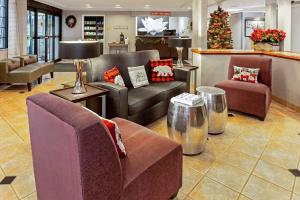 a lobby with couches and chairs and a christmas tree at La Quinta by Wyndham Milwaukee Delafield in Delafield