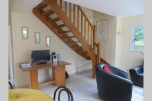 a living room with a staircase and a desk with a computer at Beg Meil in Fouesnant