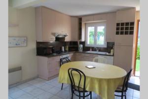 a kitchen with a table and some chairs and a table and a kitchen at Beg Meil in Fouesnant