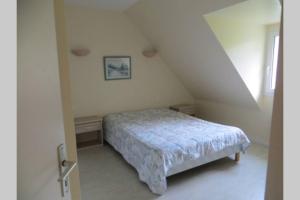 a bedroom with a bed in a white room at Beg Meil in Fouesnant