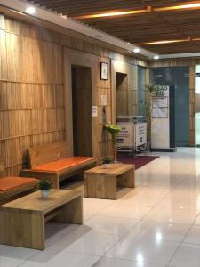 eine Lobby mit Bänken und Tischen in einem Gebäude in der Unterkunft Explorer Suite 1004 in Bacolod City + 9 Fotos