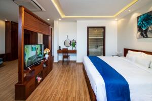 um quarto de hotel com uma cama e uma televisão de ecrã plano em Sol Villa em Hoi An
