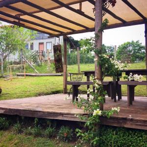 a wooden pergola with benches and a picnic table at Lavras Real in Lavras Novas