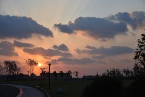 a sunset over a park with a street light at The Qube Hotel Shanghai Sanjiagang - Offer Pudong International Airport and Disney shuttle in Shanghai